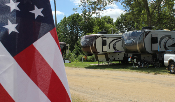 Line of RVs next to an U.S.A. flag.